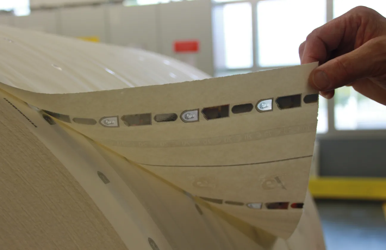 Main tient le bout de la bobine papier
