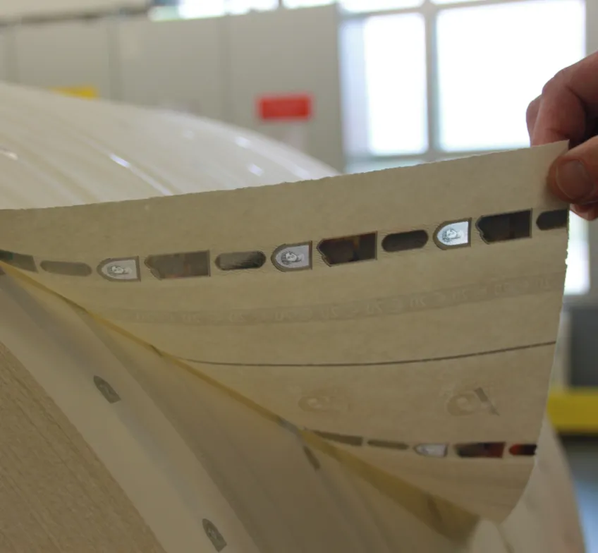 Main tient le bout de la bobine papier