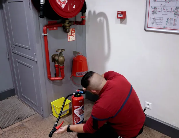 Homme qui inspecte un extincteur